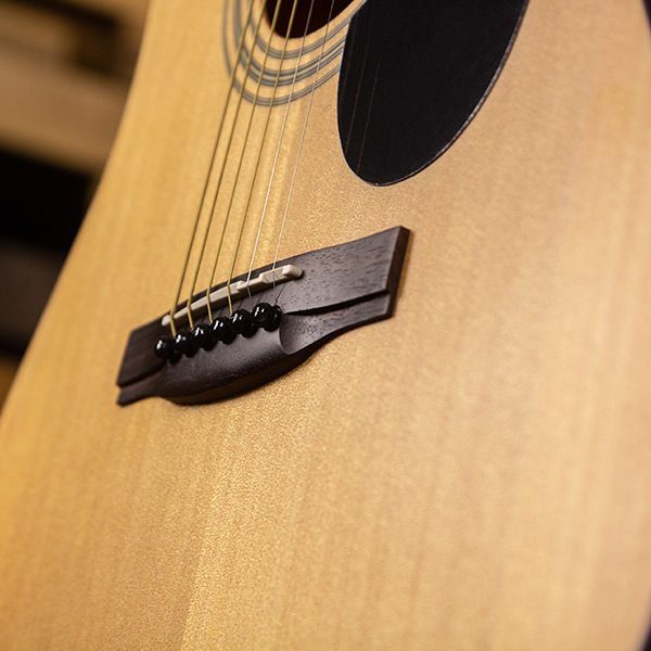 closeup of saddle and bridge on acoustic guitar